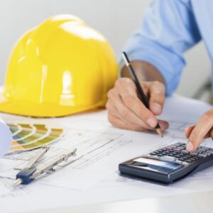 Close Up Of Male Architect Drawing On Blueprint And Using Calculator